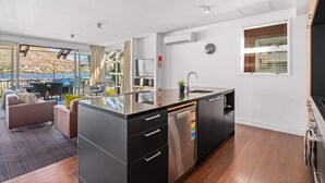 Eine moderne Küche mit Geschirrspüler, Spüle und einem Fenster mit Jalousien.