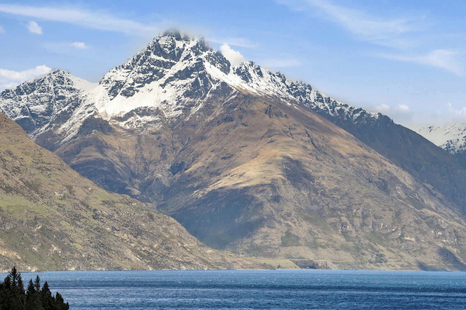 A mountainous landscape with a clear view of the sea in the foreground.