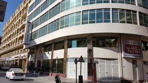 A modern hotel with multiple floors, large windows, and a curved facade.