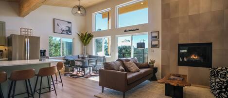 A spacious living area with a brown leather sofa, a coffee table, and a fireplace.