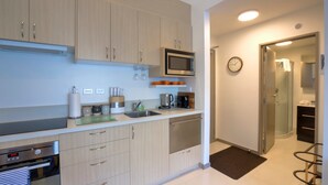 Una cucina moderna con elettrodomestici in acciaio inossidabile, mobili in legno e un forno a microonde.
