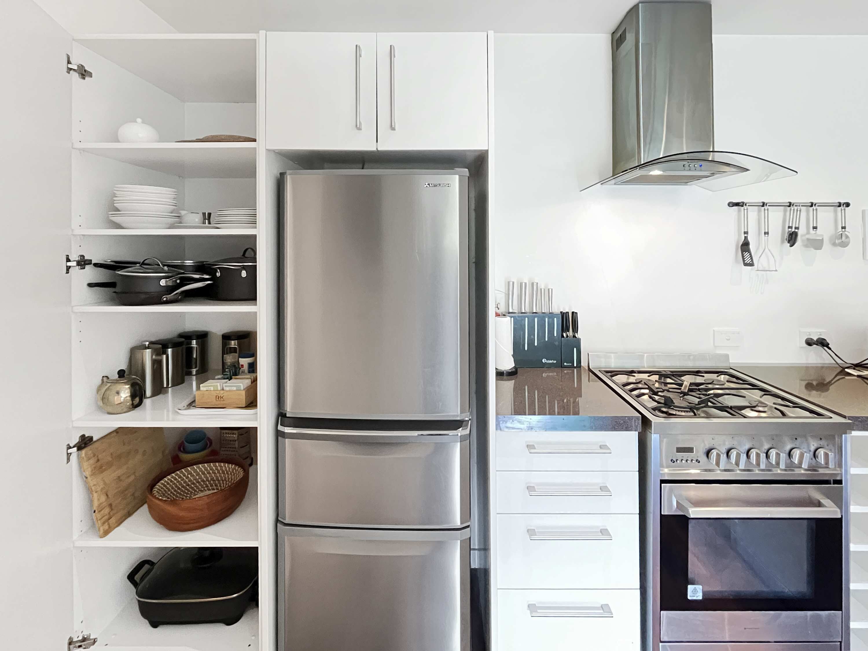 A modern kitchen with a stainless steel refrigerator, double oven, and gas stove.