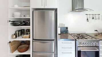 A modern kitchen with a stainless steel refrigerator, double oven, and gas stove.