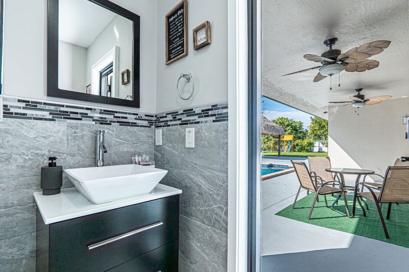 Une salle de bain moderne avec un grand lavabo, des meubles de rangement aux couleurs sombres et un miroir.