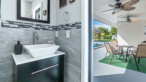 A modern bathroom with a large sink, dark cabinetry, and a mirror. - Luxury & Spacious/Large pool/BBQ/Game room/Pool (Miami)