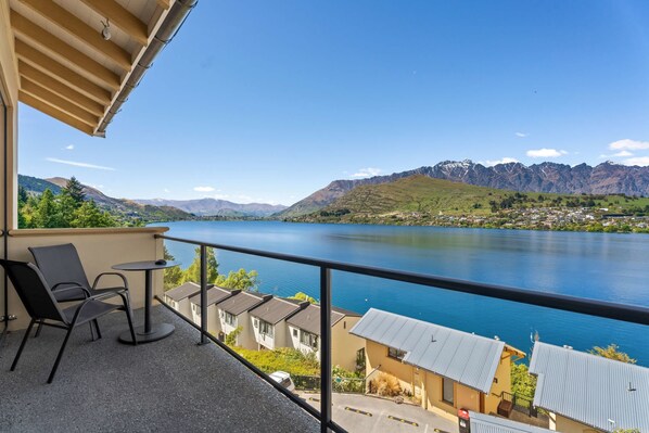 A balcony with a view of a lake and mountains.