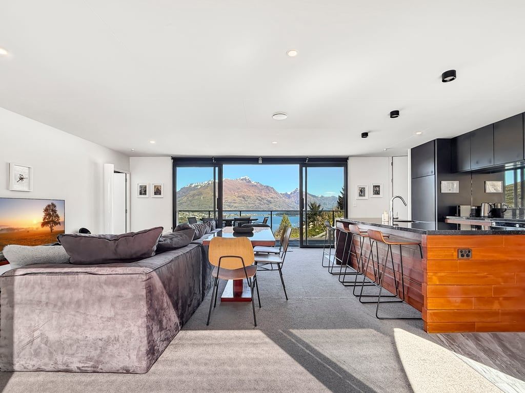 A modern interior with a sofa, dining area, and kitchen.