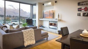 Un soggiorno moderno con un divano, un caminetto, una TV e un'area pranzo.