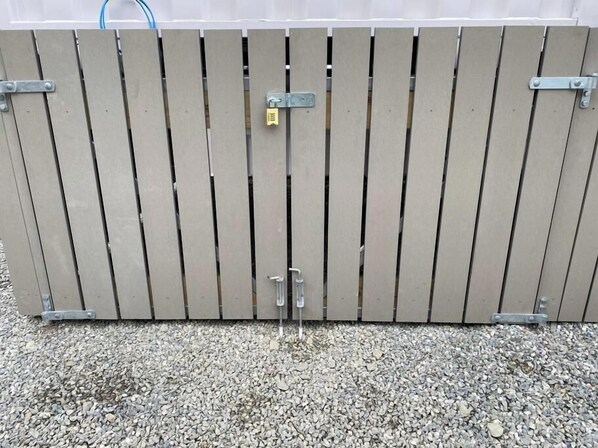 A closed metal gate with a padlock.