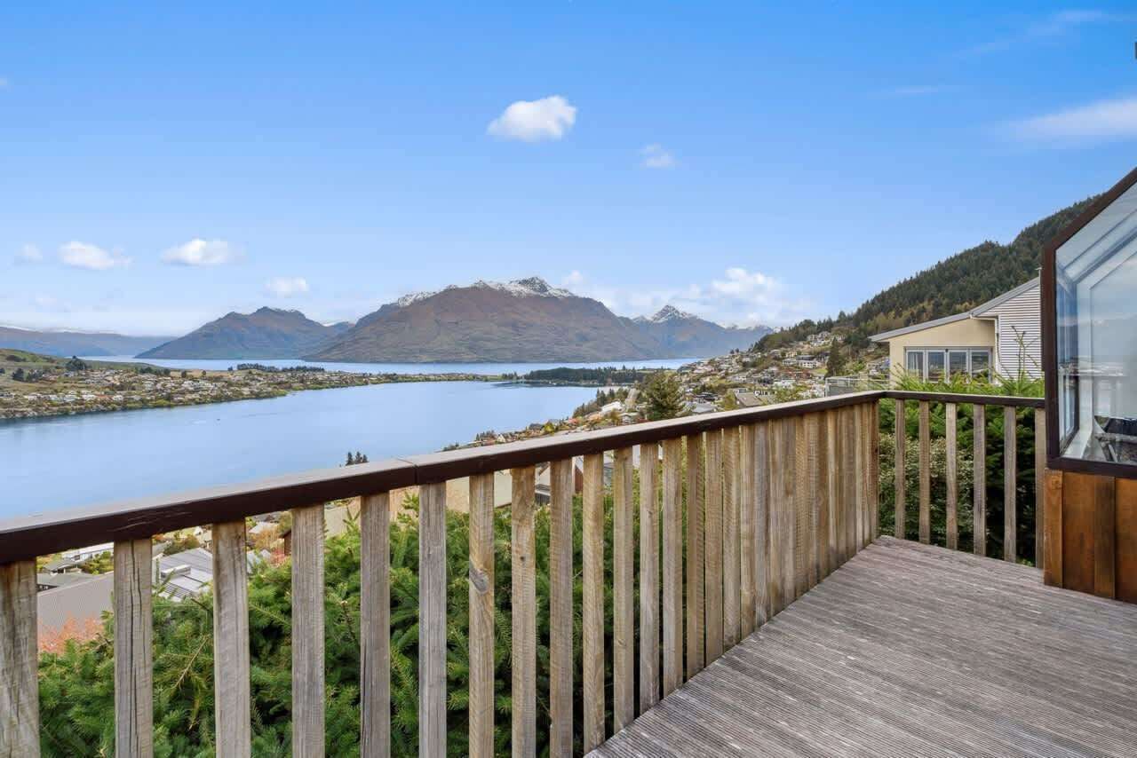 A wooden deck with a view of a lake and mountains.
