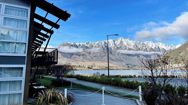 A hotel with a balcony overlooking a lake and mountains. - Marina 303A-Studio (Queenstown)