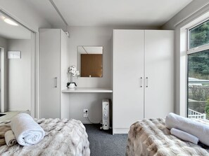 A modern bedroom with a large wardrobe, a mirror, and a view of the outdoors. - Spectacular VIEWS, 2 Bedrooms & BIG DECK! (Queenstown)