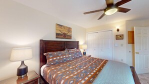 A bedroom with a wooden bed, two bedside lamps, a ceiling fan, and a door with a small picture. - Close to Lifts | Large Balcony | Mountain Spirits 103 (Angel Fire)