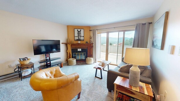 A living room with a television, leather armchair, sofa, and a fireplace. - Close to Lifts | Large Balcony | Mountain Spirits 103 (Angel Fire)