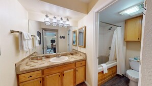 A bathroom with a wooden vanity, a large mirror, a shower, and a toilet. - Close to Lifts | Large Balcony | Mountain Spirits 103 (Angel Fire)