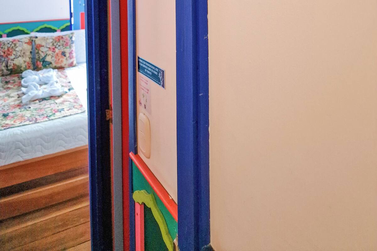 Una habitación con una cama, una puerta azul y un letrero que dice 'CIRCASIA Mythos'.