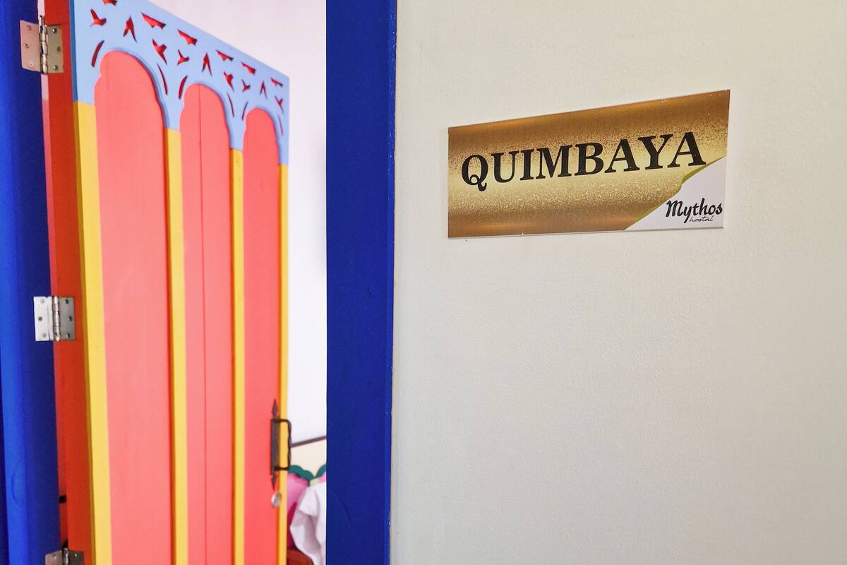 Una puerta con un letrero que dice "QUIMBAYA" y "Mythos Theater".