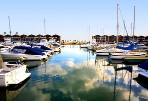 A marina with boats docked in calm waters, surrounded by covered structures. - Barkly Beachside Escape (St Kilda)