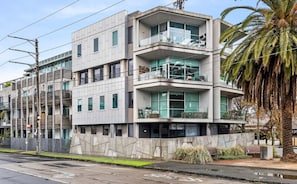 A modern multi-story building with balconies, large windows, and a concrete facade.