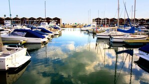Un port de plaisance où des bateaux sont amarrés dans des eaux calmes, entouré de structures abritées.