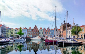 A canal with boats docked, surrounded by colorful buildings with traditional architecture.