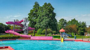 Piscina com vários toboáguas e área de recreação infantil.