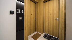 Ein moderner Aufzug mit Holztüren und einer schwarzen Wand mit der Nummer 33.