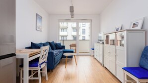 Un espacio habitable compacto con kitchenette, comedor y zona de estar con vista a la ciudad.