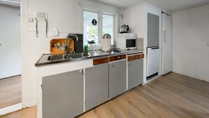 A kitchen with a sink, a kettle, a microwave, and a refrigerator. - 2 bedroom stunning home in öxnevalla (Öxnevalla)
