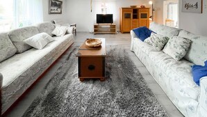 A living room with two sofas, a coffee table, a TV, and a cabinet. - 2 bedroom stunning home in öxnevalla (Öxnevalla)
