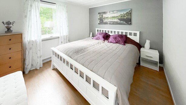 A bedroom with a bed, a dresser, a nightstand, and a window with curtains. - 2 bedroom stunning home in öxnevalla (Öxnevalla)