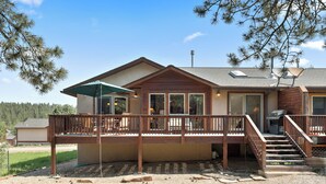 A two-story building with a covered deck and outdoor seating area. - Convenient Location | Fireplace | Pet Friendly | Country Club Villas 13 (Angel Fire)