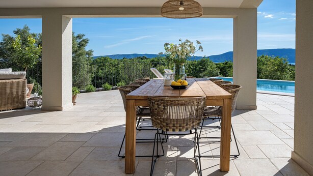 A covered patio with a wooden table and wicker chairs, overlooking a swimming pool and mountains. - Villa Terossa (Kvarner - Skrbčići) (Skrbčići)