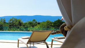 A poolside area with lounge chairs and a view of mountains. - Villa Terossa (Kvarner - Skrbčići) (Skrbčići)