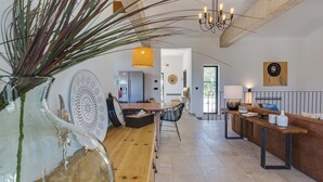 A spacious kitchen with a wooden dining table, a refrigerator, and a hanging light fixture. - Villa Terossa (Kvarner - Skrbčići) (Skrbčići)