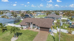 Un quartier résidentiel avec des maisons, un ciel dégagé et quelques palmiers.