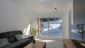 A modern living room with a sofa, coffee table, and potted plant. - Chalet du Souillet with Mountain Views, Private Terrace and Wi-Fi (Saint-Pierre-d'Entremont)