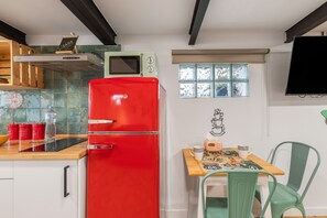 A kitchen with a red refrigerator, a microwave, and a table with chairs. - Vacation Apartment 'Loft Lisara' with Mountain View, Wi-Fi and Air Conditioning (Telde)