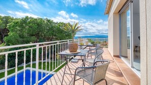 Un balcon avec une piscine, du mobilier d’extérieur et une vue sur le paysage.