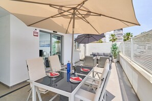 An outdoor dining area with a table, chairs, and a large umbrella.