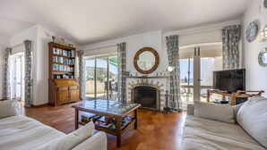 Un salon avec une cheminée, une bibliothèque, une table basse et un canapé.