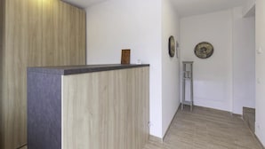 A modern interior with a wooden reception desk, white walls, and a small ladder.