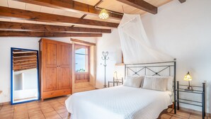 Ein Schlafzimmer mit einem Bett, einem Holzschrank und einem Fenster mit Blick.