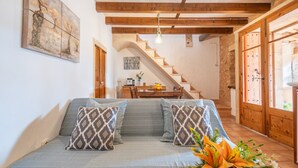 Ein Wohnzimmer mit einer Couch, einer Holztreppe und einem Essbereich.
