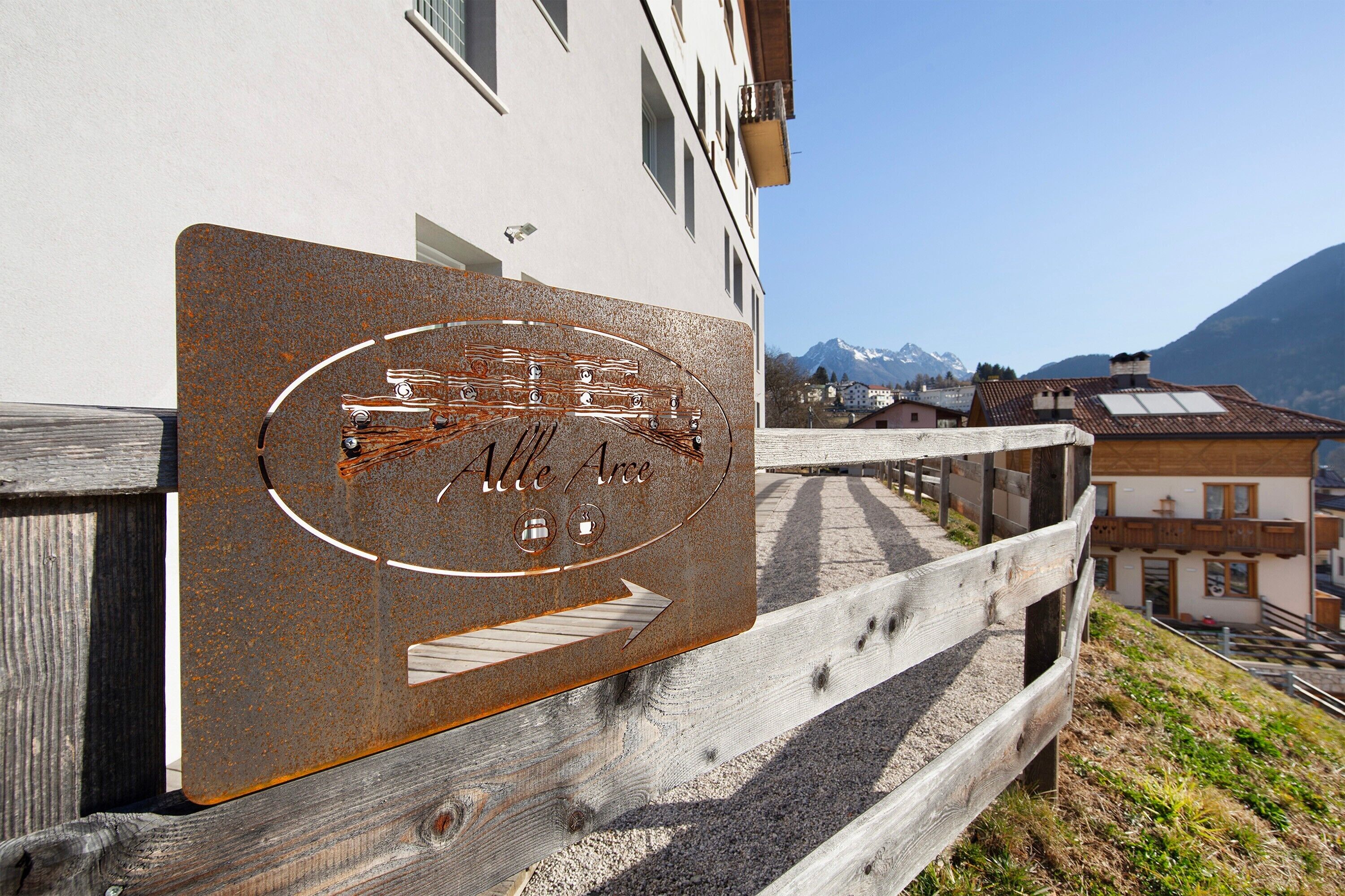 A sign with 'Alte Arce' and symbols indicating amenities like a bed, a bathroom, and a dining area.