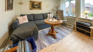 A living room with a dark grey sofa, a round wooden coffee table, a patterned rug, and a radiator near a window. - Stunning home in älekulla with WiFi (Älekulla)