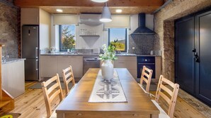 A modern kitchen with wooden cabinets, a central island, and a stone accent wall.