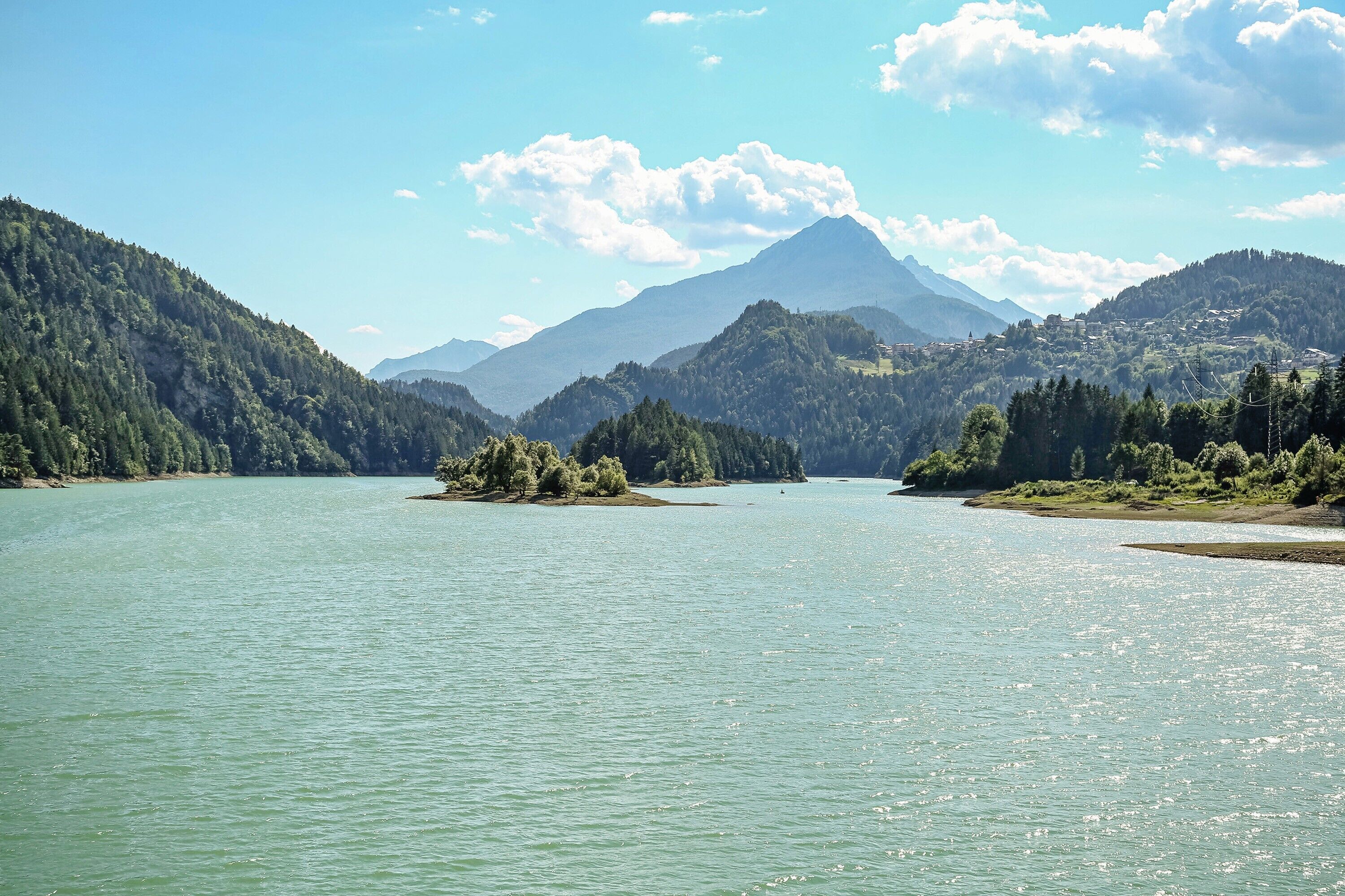 A lake surrounded by mountains and forested areas.