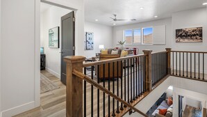 A spacious living area with a high ceiling, a wooden staircase, and a view of the outdoors through large windows. - Freedom Village 549, Smart TV, Private Balcony, Resort Amenities and more (Washington)