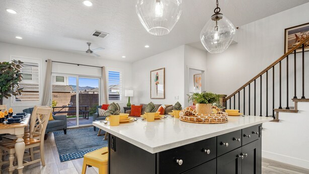 A modern kitchen with a central island, black cabinets, and a dining area with a table and chairs. - Freedom Village 549, Smart TV, Private Balcony, Resort Amenities and more (Washington)
